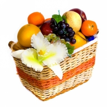 Корзина с фруктами и конфетами, украшена бутоньеркой из живых цветов